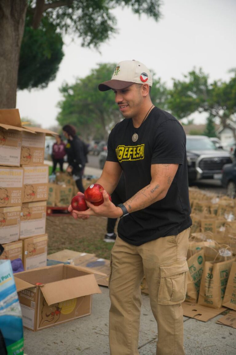 A VC Defensa volunteer sorting produce at a community despensa food distribution.